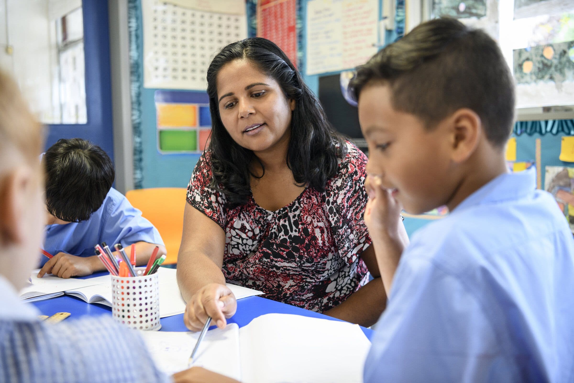 A teacher working with pupils at a classroom table